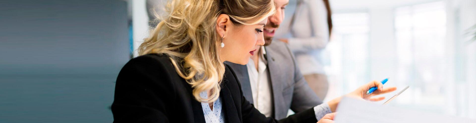 Avales y Garantías - Mujer y hombre de negocios con traje trabajando en la oficina